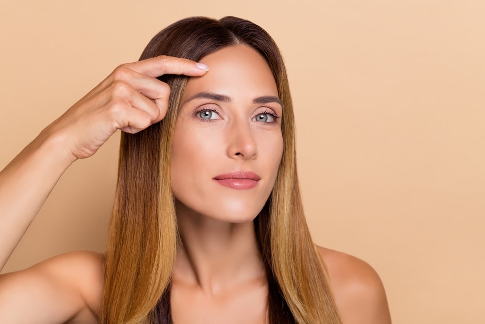 Woman touching her face after IPL or laser treatment in Littleton, CO