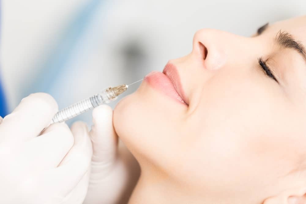 Side profile of woman getting dermal filler in Littleton, CO